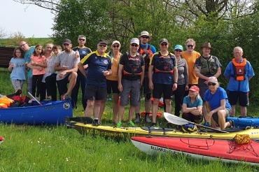 Kanufahrer hinter Kanus und Kajaks 