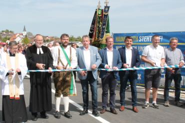 Hier sieht man Hainsfarths Bürgermeister Klaus Engelhardt (4.v.l.), MdL Wolfgang Fackler (4.v.r.) und Markus Kreitmeier vom Staatlichen Bauamt bei der Eröffnung der Staatsstraße 2216.