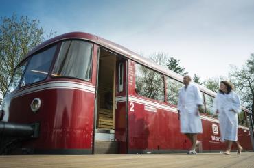 Zwei Menschen in weißen Bademänteln, die auf einem Bahnsteig laufen