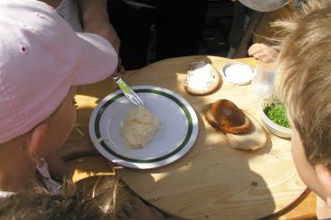 Hier sieht man Kinder bei der Herstellung von Butter.
