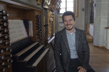 Hier sieht man André Gold vor einer Orgel.