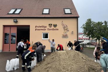 Freiwillige Helfer füllen in Nordheim Sandsäcke.