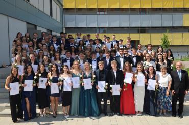 Oberstufenkoordinator Michael Demel und Schulleiterin Dr. Renate Rachidi (ganz unten von rechts) freuten sich mit den 84 Abiturientinnen und Abiturienten über die bestandenen Reifeprüfungen.