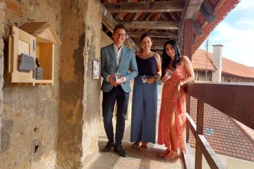 Oberbürgermeister David Wittner mit Sarah Fackler und Sarah Wörz, die für Layout und Konzeption der neuen Kinderlinie verantwortlich waren, an den neuen Stempelhäuschen auf der Stadtmauer.