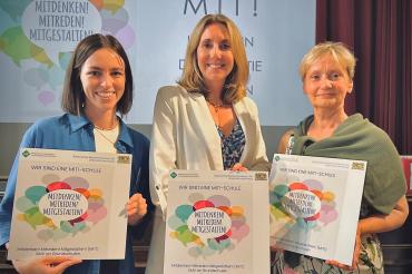 Auf dem Bild zu sehen (von links): Lehrerin Laura Mück, Kultusministerin Anna Stolz und Rektorin Margit Stimpfle.