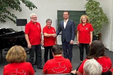 Die Chorgemeinschaft Nördlingen bekommt ihre neuen Festshirts überreicht.