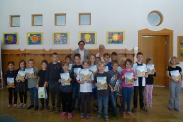 Die Kinder der dritten Klasse der Johann-Wilhelm-Klein Grundschule in Alerheim hatten großen Spaß an den Büchern „Häuser, Straßen, Tunnel bauen – wie geht das?“, die ihnen von Obermeister Wolfram Uhl von der Bauinnung Nordschwaben überreicht wurden.