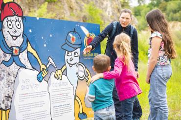 Das Bild zeigt die Geopark-Maskottchen Riesitchen und Suevitchen im Geotop Lindle.