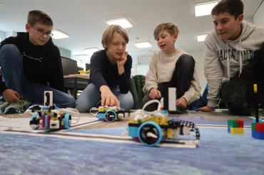 Felix Büringer, Emil Hildebrand, Sebastian Schmid und Artem Geier (v.l.n.r) programmieren in der Robotik-AG des THG Nördlingen schon die fortgeschrittenen Roboter und testen, ob ihre Roboter die entsprechenden Wege auf der Spielfeldmatte zurücklegen.