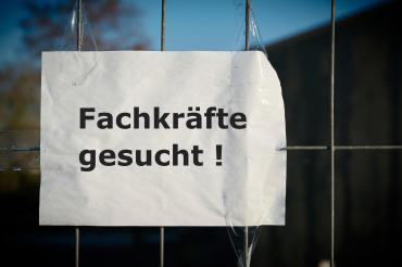 Das Bild zeigt ein Schild mit der Aufschrift Fachkräfte gesucht. 