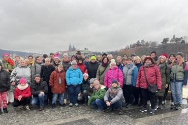 Das Foto zeigt die bunte Reisegruppe vor der Kulisse der Prager Burg.