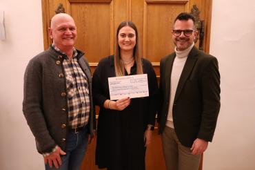 Andreas Gansmeier, der Vorsitzende des Vereins Kulinarium, und Vereinsmitglied Katharina Link übergeben einen Spendenscheck in Höhe von 2.000 Euro an Jürgen Sorré, den Vorsitzenden der Stiftung „Donauwörther Bürger in Not“.