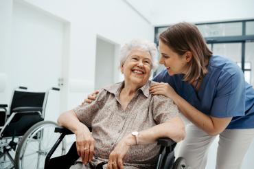 Das Bild zeigt eine Pflegekraft mit einer Seniorin. 