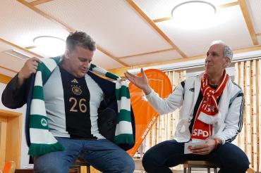 zwei Männer sitzen auf Barhockern