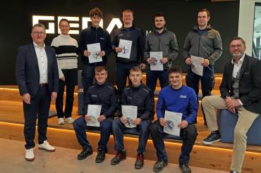 Stolz präsentieren die acht Azubis ihre Abschlussurkunden.