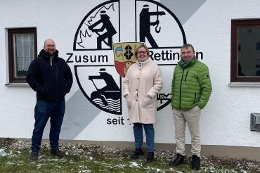 Menschen vor dem Wappen Zusum 