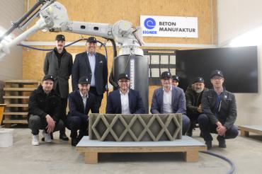 Digitalminister Dr. Fabian Mehring (M.) bei der Präsentation eines 3D-Drucks der Eigner Bauunternehmung.