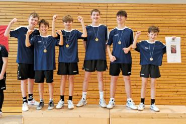 Jungs auf einem Podest mit Medaillen, die jubeln