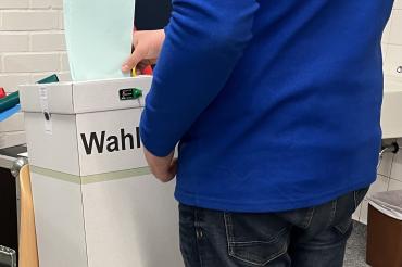 Das Bild zeigt eine Stimmabgabe. 