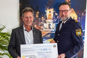 Polizeipräsident Martin Wilhelm (r.) überreicht den Scheck an Martin Obermann.