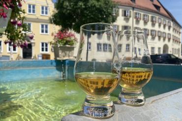 zwei whisky gläser an einem brunnen