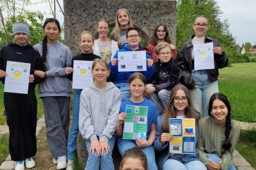 Die Mitglieder der AG Klimaschule mit den selbst gestalteten Energiespar-Plakaten sowie den Urkunden für die Gewinnerklassen.