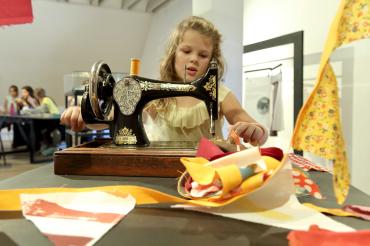 Ein Kind an einer Nähmaschine