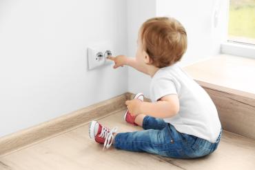 Kind fasst in Steckdose