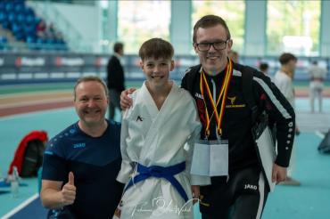 Eliah Hurler freut sich mit seinen Trainern über den Silber-Coup.