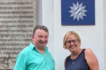 Albert Riedelshiemer und Bärbel Stahl vor einem Schild mit der Aufschrift "Polizei". 
