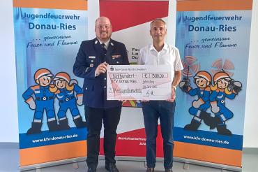 Christian Weiland (r.), Geschäftsstellenleiter der Sparkasse in Wemding, übergibt die Spende an Kreisjugendfeuerwehrwart Markus Meyr.