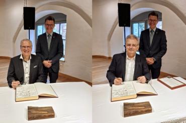 Klaus Ortler (linkes Bild) und Udo Knauer trugen sich im Beisein von Oberbürgermeister David Wittner in das Goldene Buch der Stadt Nördlingen ein. 