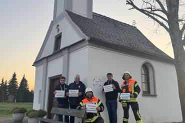 Angehörige der Freiwilligen Feuerwehr Zusum-Rettingen von der Kapelle in Rettingen, wo mit finanzieller Unterstützung von Oettinger ein Defibrillator angebracht werden soll.