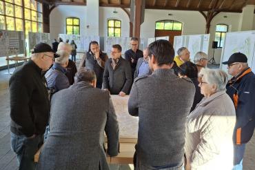 Oberbürgermeister David Wittner (Bildmitte) im Gespräch mit interessierten Bürgerinnen und Bürgern bei der Eröffnung der Ausstellung der Wettbewerbsarbeiten zum „Wohnpark Ost“.