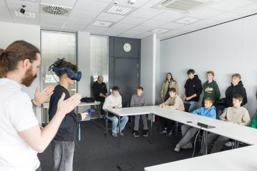 Die Schülerinnen und Schüler konnten unter Anleitung eines Mitarbeiters bei der Grenzebach Maschinenbau GmbH eine VR-Brille im unternehmerischen Kontext testen.