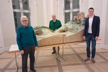 Auf dem begleitenden Bild sind Dieter Thiel, Marco Pulci und Seine Durchlaucht Fürst Moritz zu Oettingen-Wallerstein vor dem Modell von Burg- und Hölltunnel vor Schloss Harburg zu sehen.