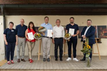 Auf der Bühne bei der Verleihung des Fotopreises des Bezirks Schwaben (v. l. n. r.): Museumsleiterin Conny Zeitler, Bezirksheimatpfleger Christoph Lang, die Zweitplatzierte Claudia Specht, der Erstplatzierte Peter Hildebrand, stellvertretender Bezirkstagspräsident Peter Schiele, der Drittplatzierte Gregor Hanewacker und Edgar Rölz (Kulturbeauftragter Bezirk Schwaben, Bezirksrat).