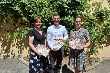 Der Countdown für die Sommerferien läuft: Mit  dem neuen Flyer startet das Ferienprogramm 2026 bald in die  Anmeldephase (v. l.: Simone Leidel, Oberbürgermeister David  Wittner, Jugendsozialarbeiterin Nina Thorwart).