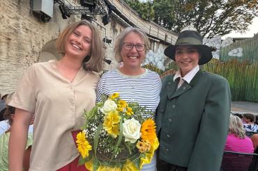 Marei (Julia Völkl) und Mogli (Ninivee Weichenmeier) begrüßen Martina Gerstmeier als 17.000. Besucherin der Spielzeit 2026 auf der Freilichtbühne Alte Bastei. 