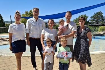 Ein besonderer Freibadbesuch für Familie Hillenmeyer: Als 100.000. Besucher der Saison erhielten Nina und Max Hillenmeyer sowie ihre Kinder Lorenz, Emil und Ida eine Saisonkarte für die ganze Familie und ein Badetuch. Die Glückwünsche überbrachten Nicole Hofmann (links), 2. Bürgermeister Steffen Höhn (2. v. l.) und Simone Leidel (rechts). 