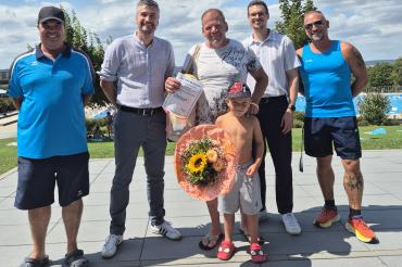 Bürgermeister Jonathan Schädle (2.v.l.) begrüßt Jürgen Miehle (m.) und seinen Sohn Lennox im Donauwörther Freibad. 