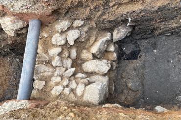 Die gefundene Mauer samt dem Rest des Holzpflocks (dunkle Stelle rechts oben neben der Mauer)