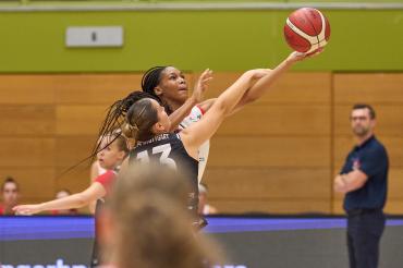 Wirklich kein Foul-Pfiff? Makiyah Williams wird beim Korbwurf gestört, trifft aber trotzdem. Die US-Amerikanerin war Topscorerin beim Match gegen Stuttgart. Headcoach Rozitis beobachtet die Szene im Hintergrund.
