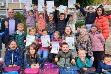 Kinder und Lehrkraft der Grundschule Deiningen freuen sich mit (stehen v. links). AOK-Direktorin Michaela Kluger und AOK-Beirat Bruno Schönherr.