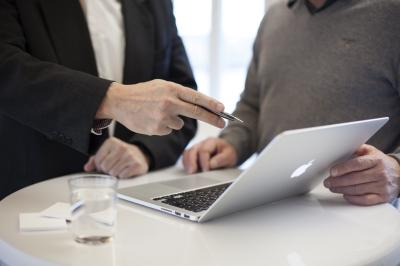 Zwei Männer an einem Stehtisch mit Laptop
