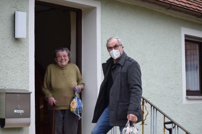 Das Bild zeigt Fritz Fischer von den Helfenden Händen, wie er „Ebbas Warms“ an die 95jährige Anna Bachinger in Wörnitzostheim übergibt.