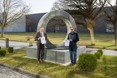 Das Bild zeigt Landrat Stefan Rößle und Prokurist Friedrich Gerlinger bei der Urkundenübergabe. 