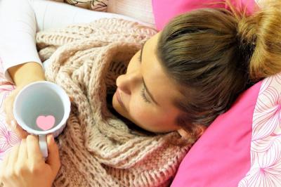 Das Bild zeigt eine kranke Frau im Bett. 