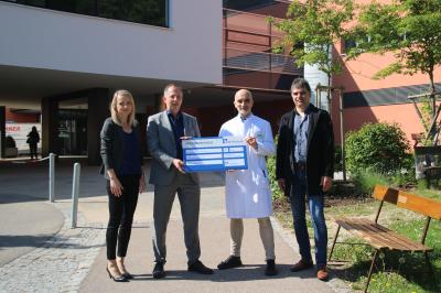 Zu sehen sind Mareike Baumann, Jürgen Neumann, Dr. Thomas Klaus Schmitt und Helmut Gerstmeier bei der Spendenübergabe vor dem Stiftungskrankenhaus. 
