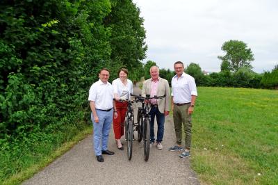 Ulrich Lange, Claudia Marb, Georg Stoller und Alexander Wolfinger mit Fahrrädern auf einem Radweg. 